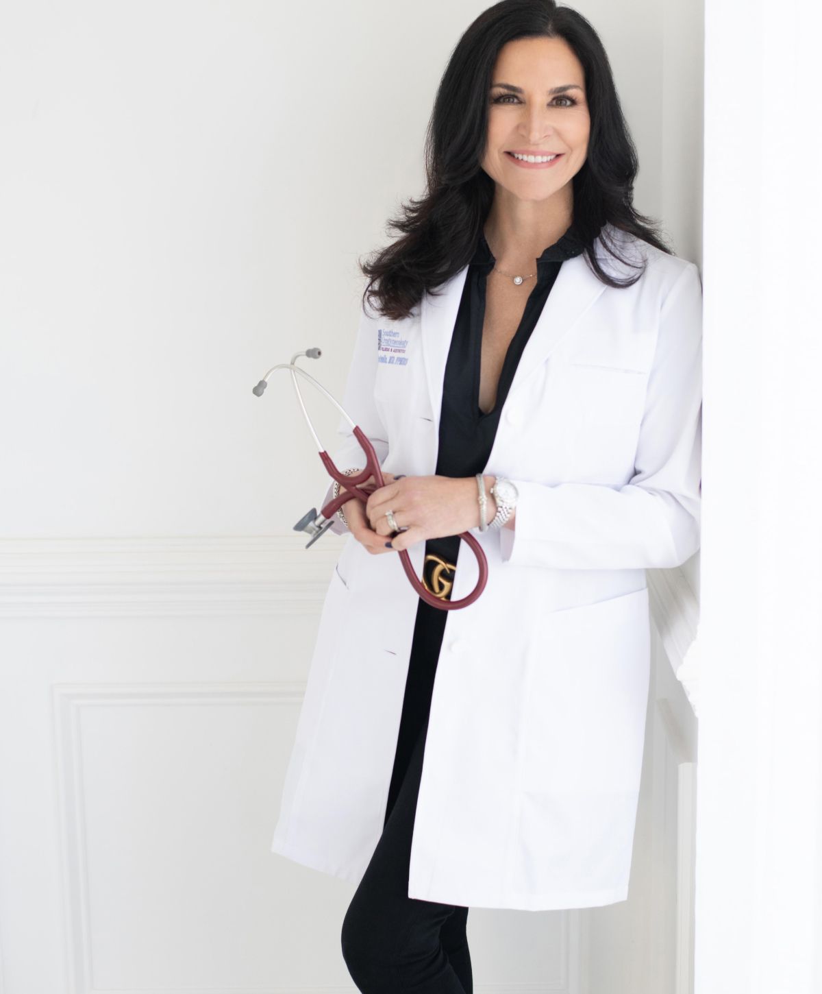 Medical professional in white coat, smiling confidently.