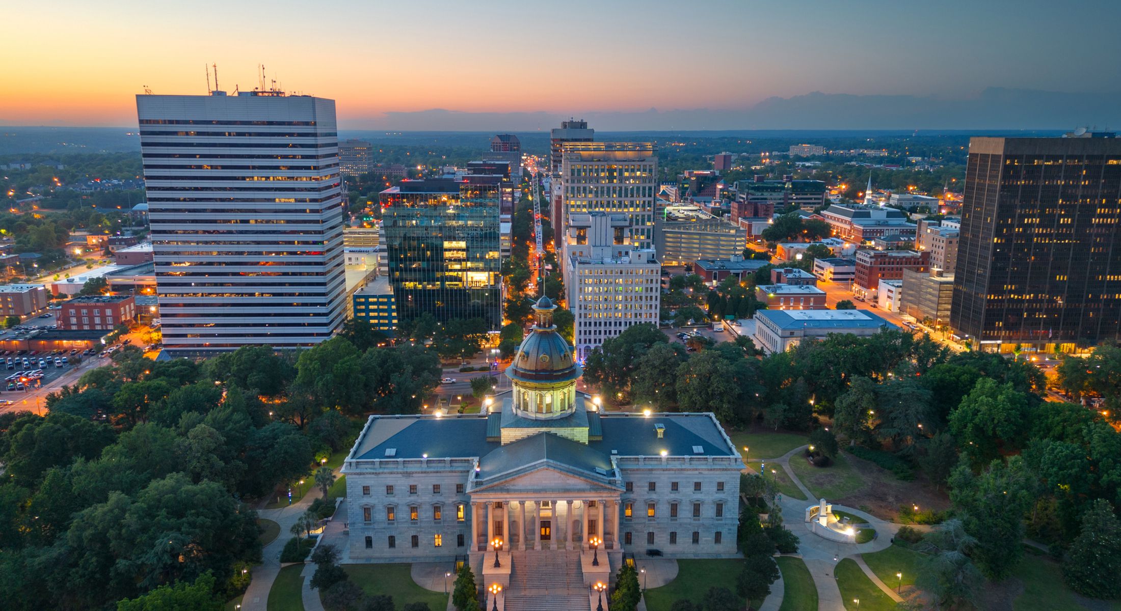 City skyline at sunset with historic building foreground.